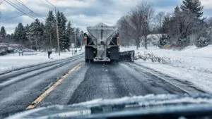 Winter road being treated with ice melt